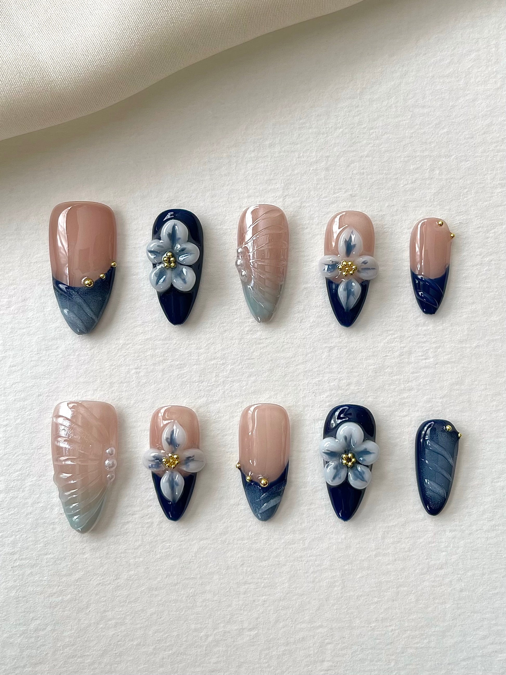 Blaue Mandelnägel mit filigraner 3D-Blumen-Gravur