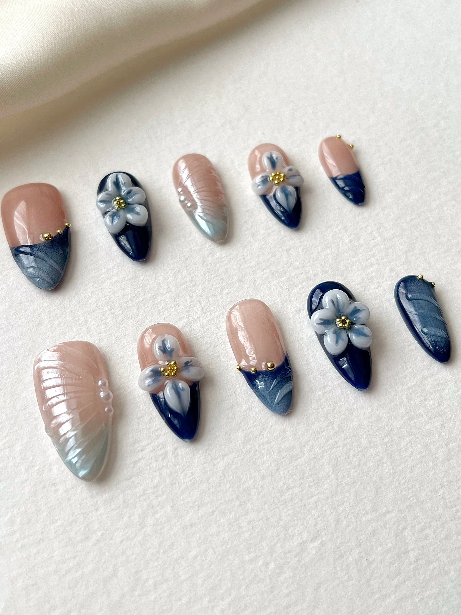 Blaue Mandelnägel mit filigraner 3D-Blumen-Gravur