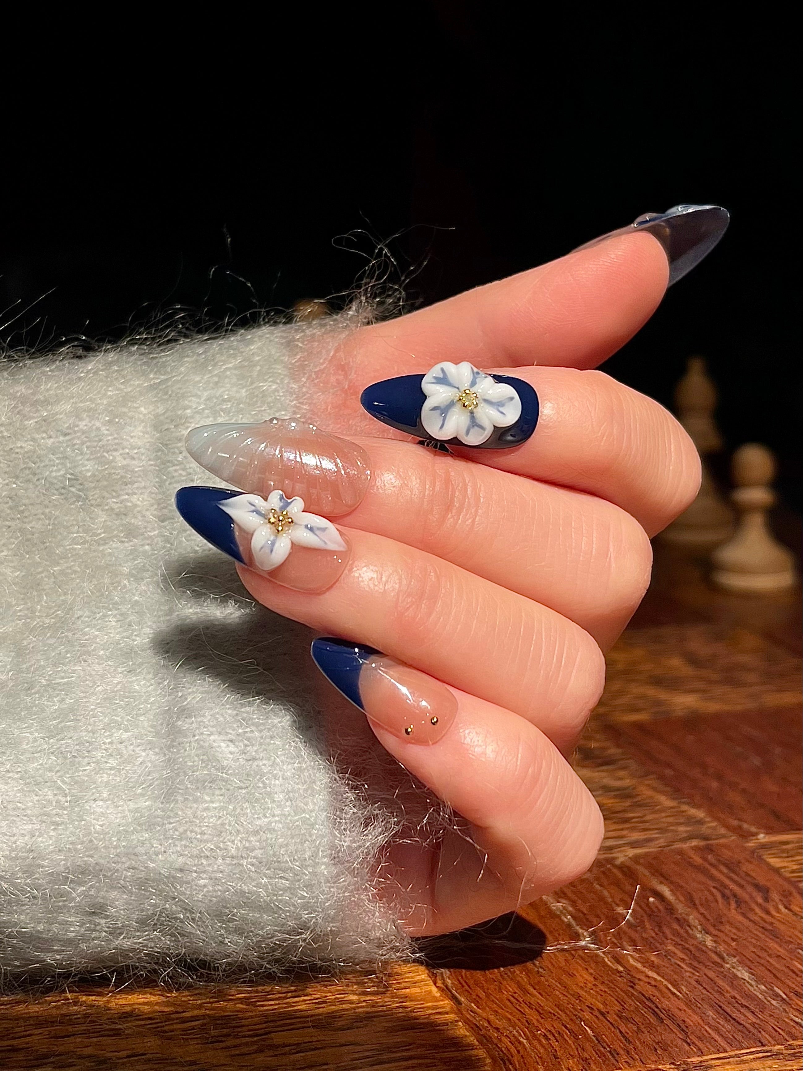 Blaue Mandelnägel mit filigraner 3D-Blumen-Gravur